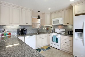 Double sinks, dishwasher, microwave, gas oven, and fully stocked kitchen