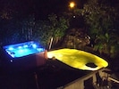 A lit up at night, 8 Person Hot Tub, Waterfall, and Koi Pond.  
