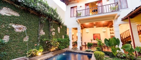 Tropical courtyard and 40' pool at dusk.  Master bedroom balcony overlooks pool