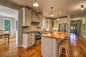 Gas stove, stocked with dishes, pots, pans, basic spices,  separate pantry