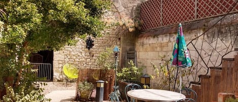 Cour intérieure, table de jardin, partie troglodyte  pouvant abriter vos vélos