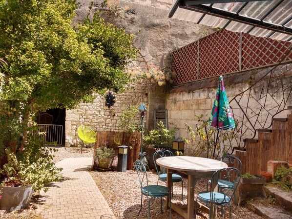 Cour intérieure, table de jardin, partie troglodyte  pouvant abriter vos vélos