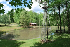 View of cabin and antique windmill in the summer.