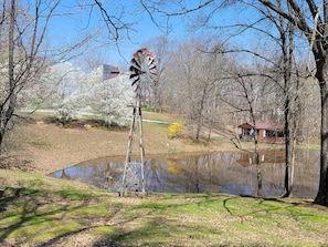 View of antique windmill and cabin in early spring.