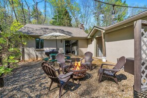 Sit by the fire in our Adirondack chairs with the string lights glowing above!