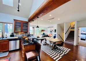 Open flow from Living Room & fresh cut flowers.  Dining table seats 8 people. 