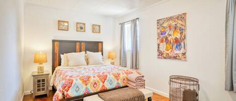 Cozy bedroom featuring a comfortable queen bed, abundant natural sunlight.