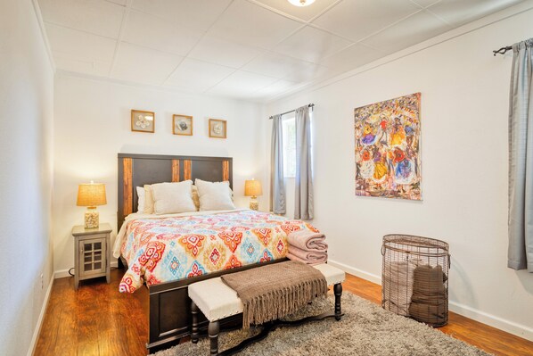 Cozy bedroom featuring a comfortable queen bed, abundant natural sunlight.