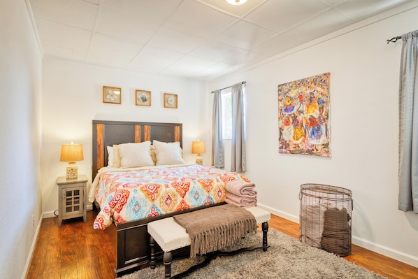 Cozy bedroom featuring a comfortable queen bed, abundant natural sunlight.