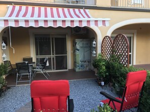 Patio area with sun awning and table and chairs with parasol