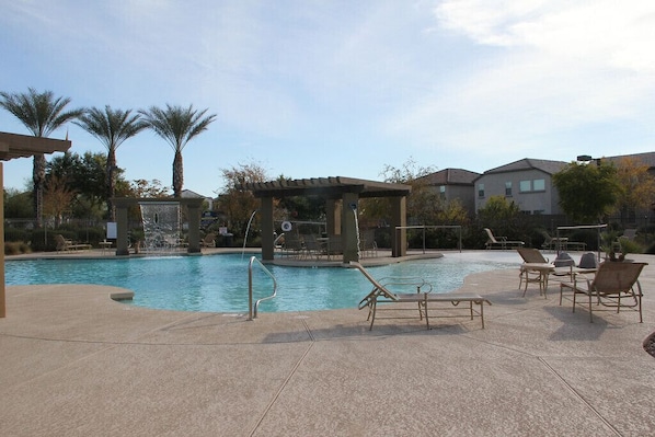 Community pool with water features, palm trees and hot tub.
