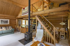 Main living space with wood Stove. Steps up to the loft and down to bedrooms.