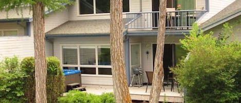 Back view of condo with deck and hot tub where you can relax and enjoy the view.