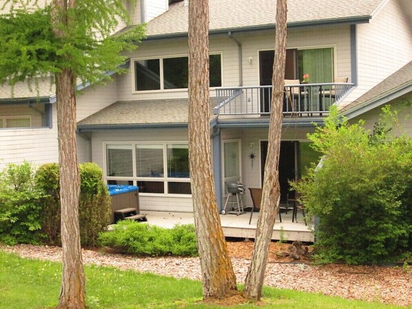 Back view of condo with deck and hot tub where you can relax and enjoy the view.