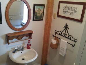 On your right is half bath with toilet, pedestal sink & stack washer/dryer.