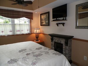 King size master bedroom with a fireplace and TV.