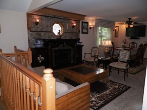 Main level living room with fireplace open to a dining area.