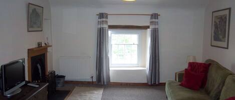 Spacious lounge with freeview television and working open fireplace.