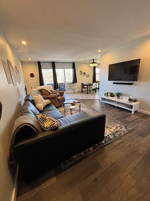 Living area from entry looking to balcony. Pull out sofa. Smart TV. Sound bar. 