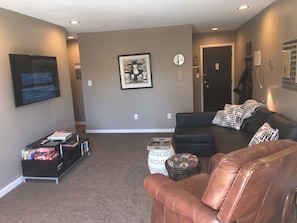 Living room with 55" flat screen tv and the black couch easily makes into a bed.