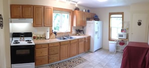 Kitchen includes a large variety of modern cooking utensils and new appliances 