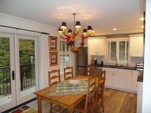 Ample dining space and fully equipped kitchen; French doors to balcony. 