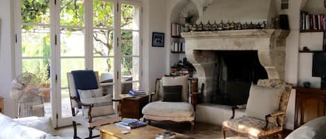 Main Floor living room, opening to terrace, yard, & rose garden. Balcony to left