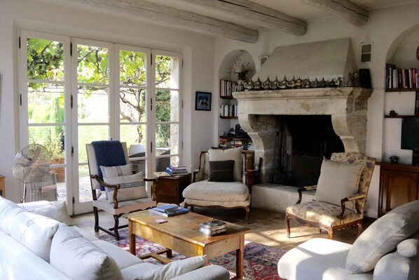 Main Floor living room, opening to terrace, yard, & rose garden. Balcony to left