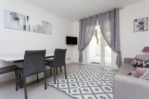 A television with cable TV with a comfortable sofa and a dining-room