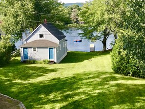 Back of house with flat lawn area to relax or play yard games