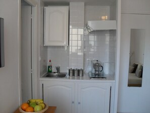 Kitchenette with sink, electric hob, fridge/freezer and microwave oven