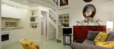 Living Room with double sofa bed, armchair, TV and full kitchen.