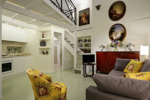 Living Room with double sofa bed, armchair, TV and full kitchen.