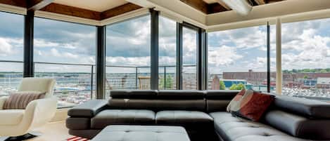 Large living area with expansive views of harbor and city.