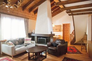 Spacious living room, fireplace and dining area beyond.  Door to balcony. 