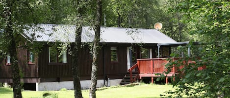 cabin with covered deck area and hot tub