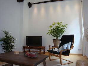 Living room with sofa and arm chair with view of church square