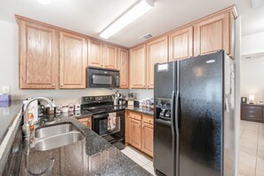 Well equipped kitchen with black granite counter-tops.