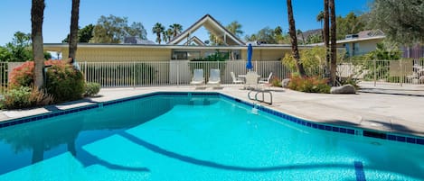 Large, pristine, heated pool with Mid Century A line roofs in view