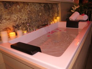 A relaxing oasis provides a soothing sensual experience in the deep soaking tub