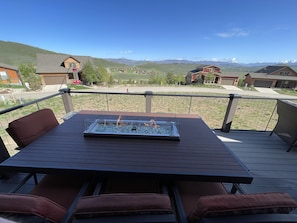 8-person outdoor dining table with gas fire in middle, and mountain views.