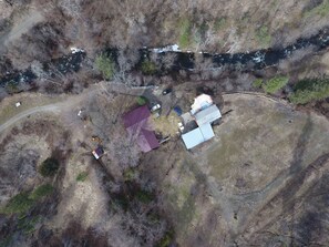 Drone aerial view of the cabin (burgundy roof) and the lodge