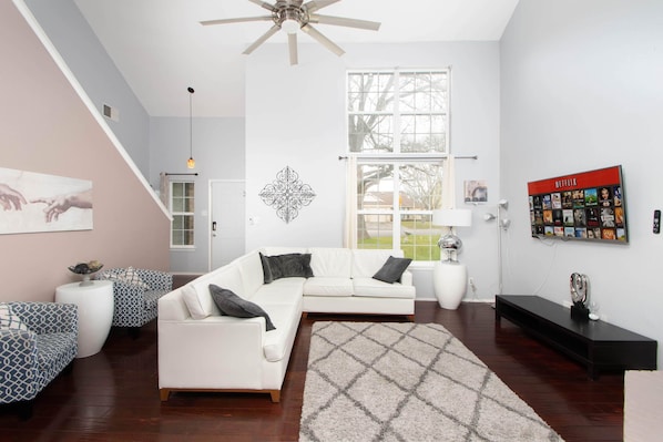 Main floor living room with large windows and 2 stories. Opens to kitchen dining