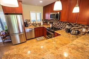 Beautiful kitchen with granite counters and full size stainless appliances.