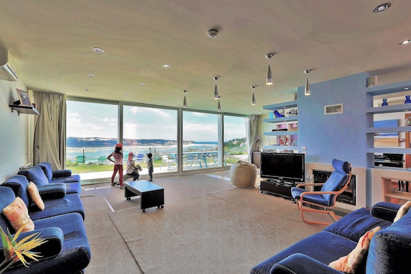 Large living room with sun terrace and doors opening widely