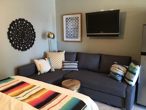 Living room area with queen size sleeper sofa and cable TV.