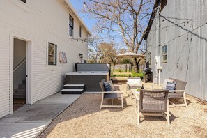 Private courtyard with hot tub, lounge seating, picnic table, and grill.