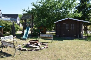 Kinderspielplatz mit Rutsche, Sandkasten und Chillbereich;  Schuppen 