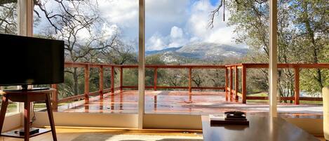 View of our new Redwood Deck from the great room showing some snow in the hills.