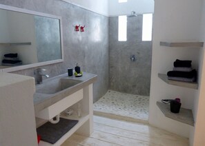 Ensuite bathrooms in polished concrete, with walk-in shower and private toilets.
